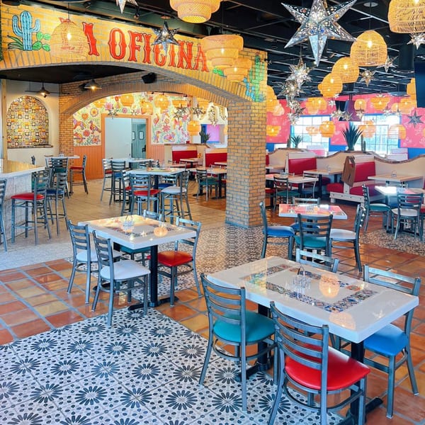 Vibrant El Paso Tacos & Tequila dining room with colorful murals, star lanterns, and diverse seating.