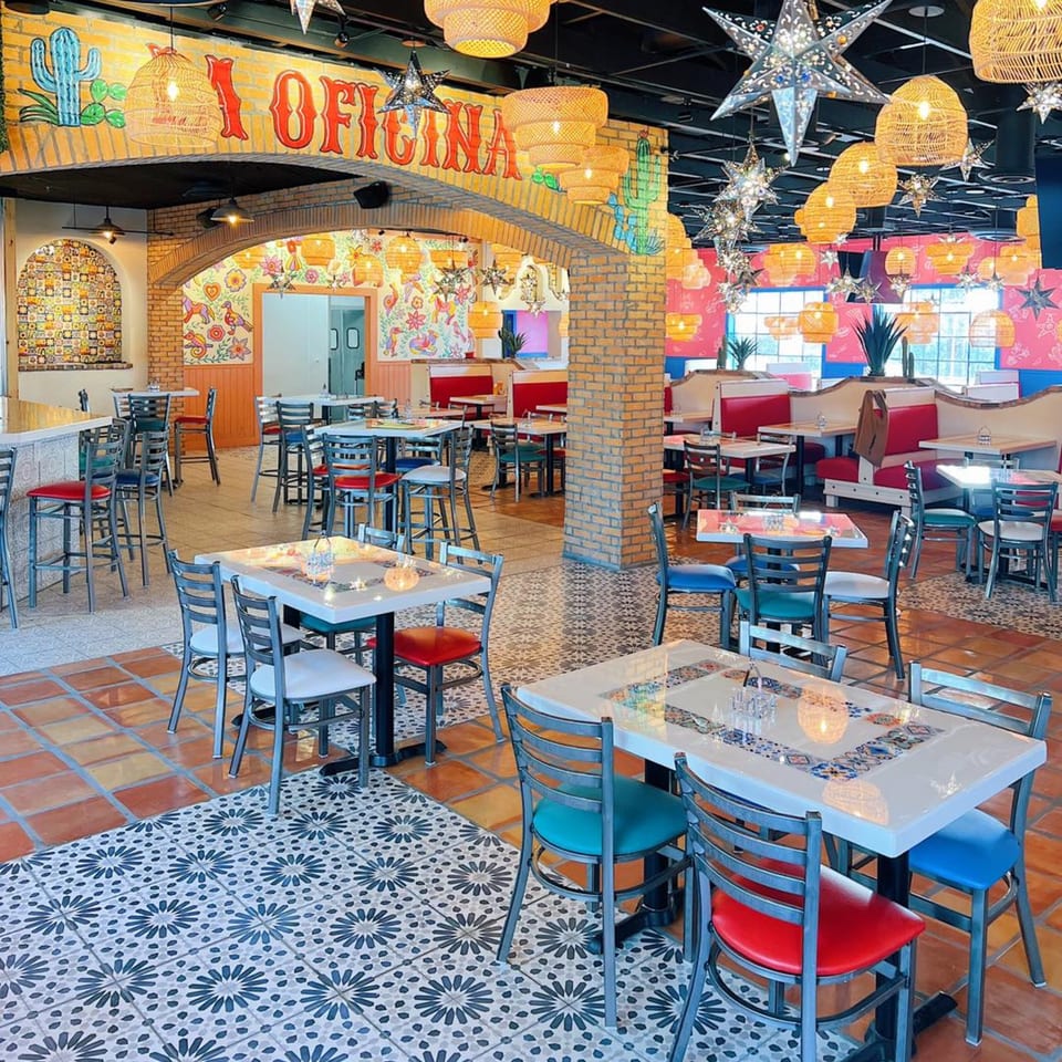 Vibrant El Paso Tacos & Tequila dining room with colorful murals, star lanterns, and diverse seating.