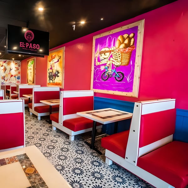 Vibrant El Paso Tacos & Tequila dining room with red booths, colorful murals, and patterned floor tiles.