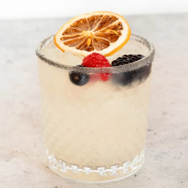 El Paso Tacos & Tequila's margarita with berries, a dried orange slice, and a sugar-rimmed glass.