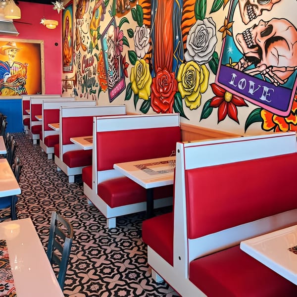 El Paso Tacos & Tequila dining room with red booths, patterned floor, and colorful Mexican-themed murals.