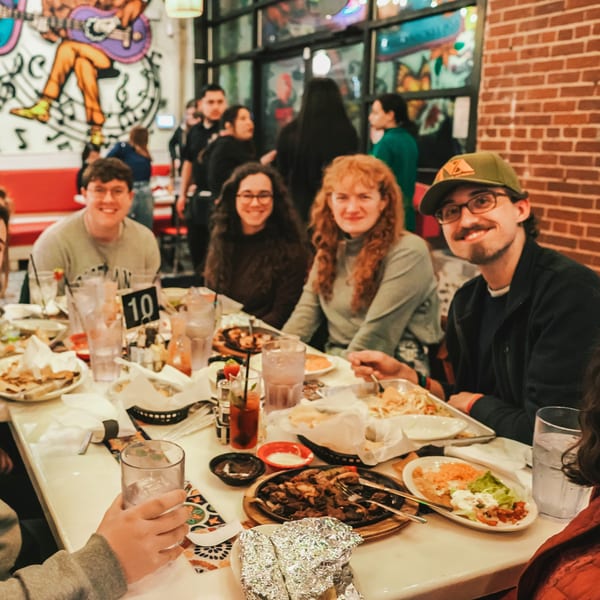 Friends enjoying a meal of fajitas and other Mexican dishes at El Paso Tacos & Tequila.